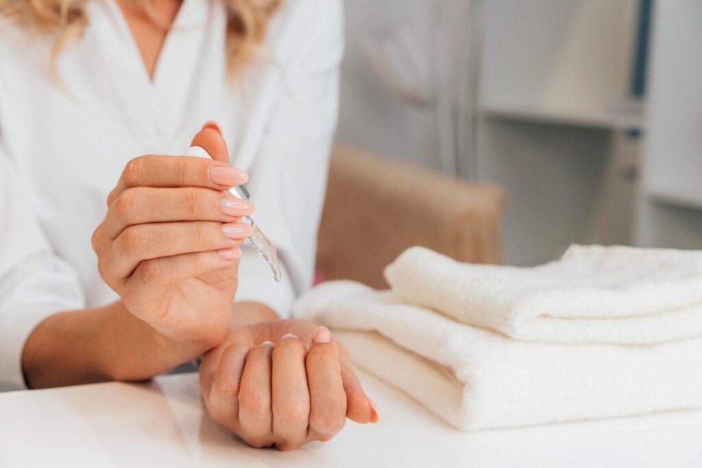 a person using some natural remedies on her nails and cuticles