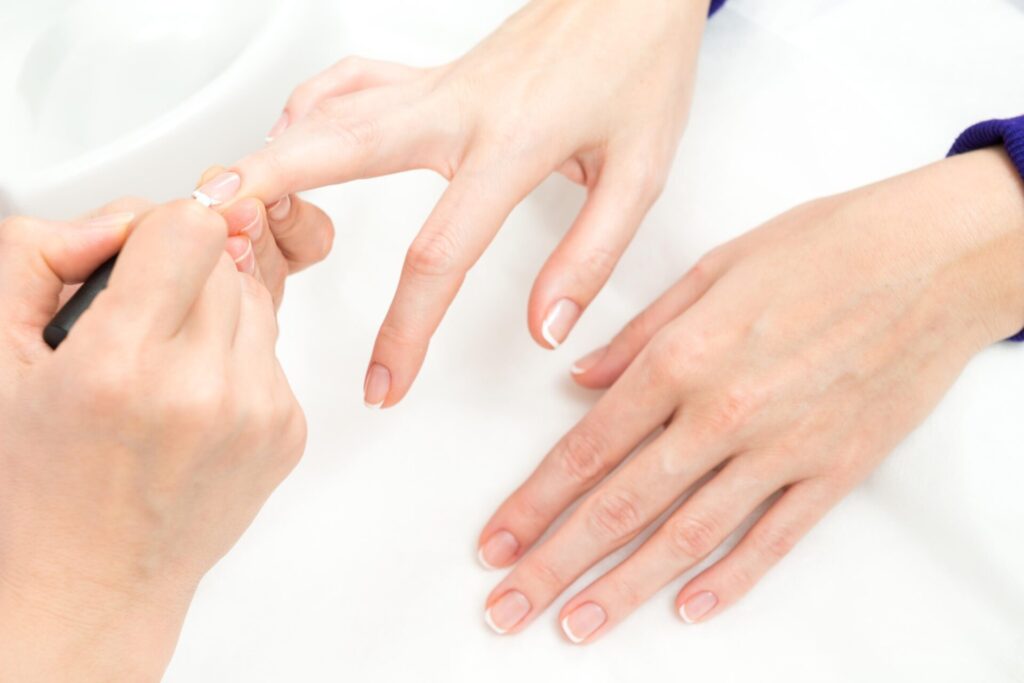 a person getting her manicure done in a salon