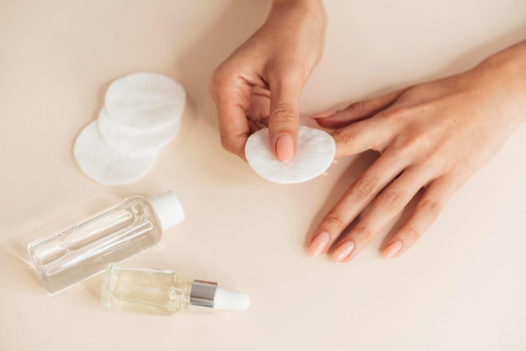 Hydrating her nails with some coton pads